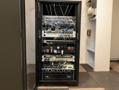 Server rack containing network switches, patch panels, and connected cables in a data centre.